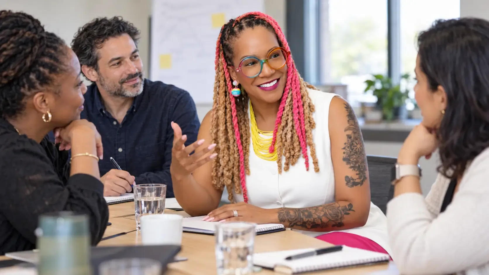 Angela Briggs-Paige leading a conversation with colleagues around a workshop table